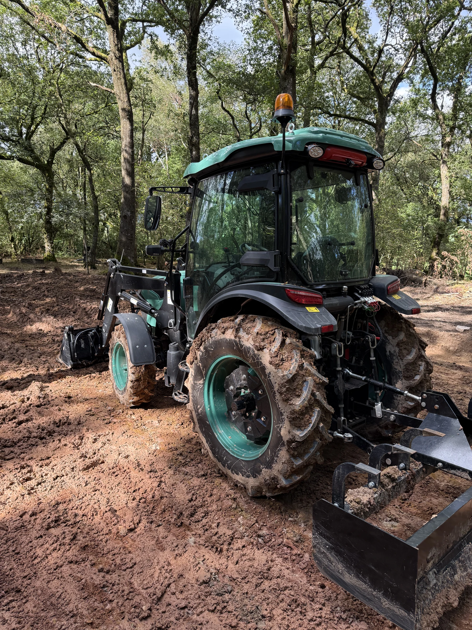 Rear view of the BULL with its hydraulic connections and attached HW eight-foot box grader