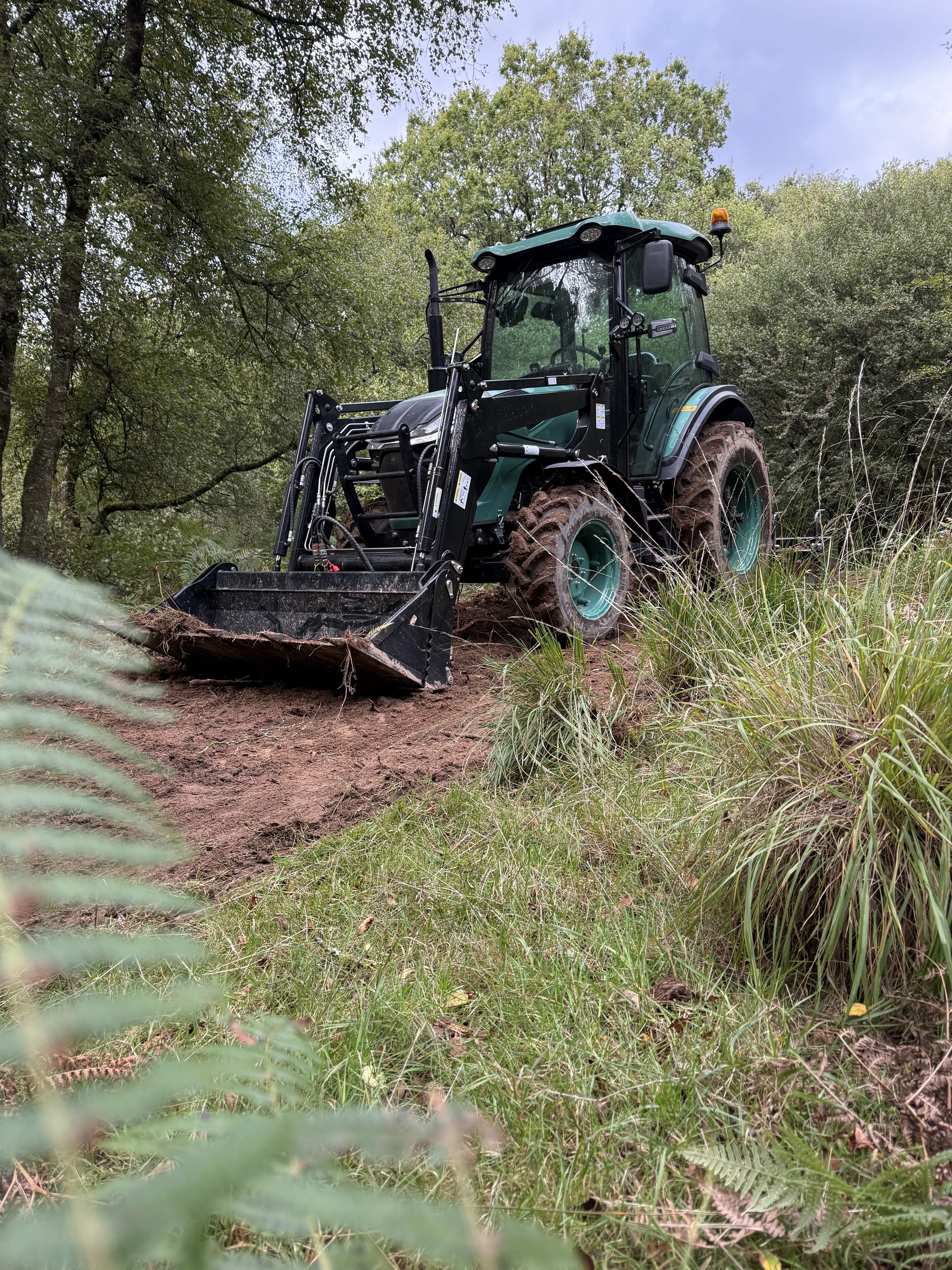 The HOP-WOOD BULL using its HW Series 10 loader on a woodland track